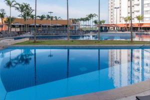uma grande piscina de água azul num resort em Ideal para famílias, hospede-se no Solar das Águas. em Olímpia