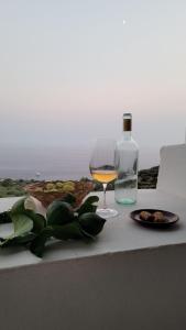 ein Glas Wein und eine Flasche auf dem Tisch in der Unterkunft Salina Castel Vinci in Rinella