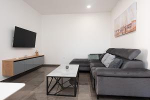 a living room with a couch and a tv at Apartment MM in Sukošan