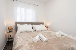 a bedroom with a large bed with two towels on it at Apartment MM in Sukošan