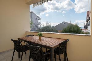 una mesa y sillas en un balcón con ventana en Apartment MM, en Sukošan