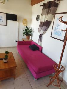 a living room with a purple couch and a table at anastasia holiday apartments in Paphos City