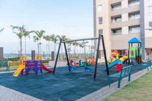 um parque infantil com equipamento de recreio colorido em frente a um edifício em Ideal para famílias, hospede-se no Solar das Águas. em Olímpia