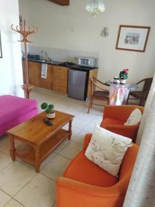 uma sala de estar com cadeiras laranja e uma mesa de centro em anastasia holiday apartments em Pafos