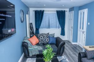 テルフォードにあるImpeccable 4-Bed House in Telford West Midlandsの青い壁のリビングルーム(ソファ付)
