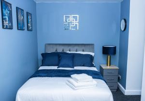 a blue bedroom with a bed with towels on it at Impeccable 4-Bed House in Telford West Midlands in Telford