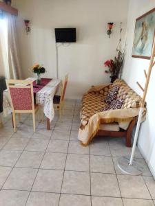 sypialnia ze stołem i łóżkiem oraz stołem i krzesłami w obiekcie anastasia holiday apartments w Pafos