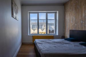 a bedroom with a bed and a large window at L Etoile de Boulogne proche plage et nausicaa in Boulogne-sur-Mer