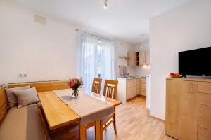 een woonkamer met een eettafel en een keuken bij Fröhlichhof Wohnung Apfelblüte in Lagundo