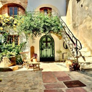 a house with a green door and a staircase at Oliva Courtyard Guesthouse in Oliva