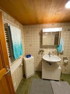 un piccolo bagno con lavandino e specchio di 1 room apt, kitchen, patio, in beautiful chalet a Les Diablerets