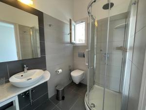 W łazience znajduje się prysznic, umywalka i toaleta. w obiekcie Anna's Studio w mieście Piso Livadi