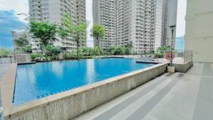 a large blue swimming pool with tall buildings at Muji-Inspired 2BR 2BA Apartment, 8 Mins to CIQ, Sleeps 2-6 in Johor Bahru