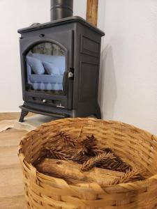 a basket in front of a wood stove at POUSADA SERTÃO DA BOCAINA in Cunha