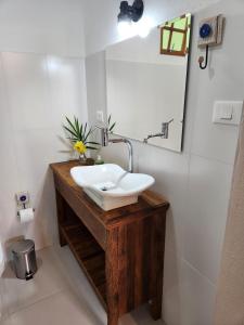 a bathroom with a white sink on a wooden counter at POUSADA SERTÃO DA BOCAINA in Cunha