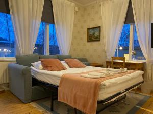 sypialnia z łóżkiem, kanapą i oknami w obiekcie Borgs Villahotell och B&B w Norrköping