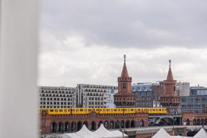 Blick auf eine Stadt mit einem gelben Zug in der Unterkunft Homaris East Side Hotel - Mobile Key Access in Berlin