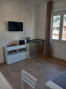uma sala de estar com um micro-ondas e uma televisão em Milly Rooms em Celle Ligure