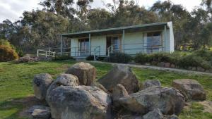 a house with a bunch of rocks in front of it at Warby Cottage in Wangaratta