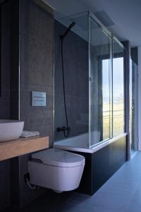 een badkamer met een toilet, een bad en een wastafel bij HOTEL PORTOMARÍN STAR in Portomarin