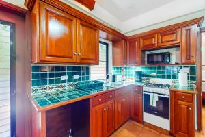 a kitchen with wooden cabinets and a stove top oven at Condo #25 @ Beachside Villas in Placencia