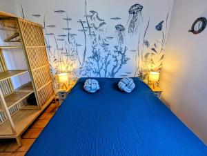 Appartements L'Acacia - plage d'Argent à 300m في كوتي شْيافاري: غرفة بسرير ازرق وملاءات زرقاء