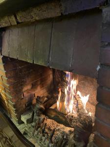 a brick fireplace with a fire in it at Hôtel Chastellares in Auron