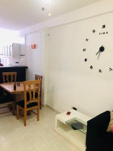 a living room with a table and a clock on the wall at Apartamento en zona de Torices in Cartagena de Indias