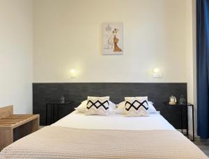 Un dormitorio con una gran cama blanca con dos almohadas. en Résidence Victoria, en Vichy