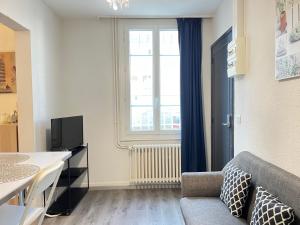 a living room with a couch and a window at Résidence Victoria in Vichy