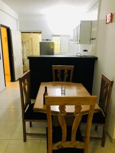 a wooden table and chairs with a kitchen in the background at Apartamento en zona de Torices in Cartagena de Indias