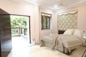a bedroom with a bed and a large window at CORAL VILLA in Lonavala