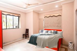 a bedroom with a bed with a red headboard at CORAL VILLA in Lonavala