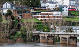 a bridge over a river with buildings in the background at HOTEL PORTOMARÍN STAR in Portomarin