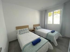 ein Schlafzimmer mit zwei Betten und einem Fenster in der Unterkunft Aguja, Villa con piscina y barbacoa para disfrutar in Puerto Calero + 17 Fotos