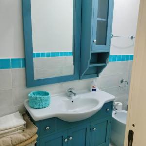bagno con lavandino blu e specchio di PM 22 Via Cala Sabina Guest House a Stintino