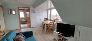 a living room with a blue couch and a television at Schippkieker in Heikendorf