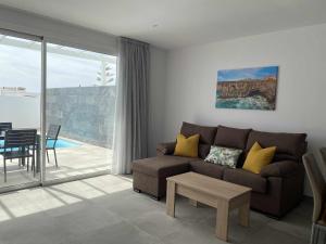 ein Wohnzimmer mit Sofa und Tisch in der Unterkunft Aguja, Villa con piscina y barbacoa para disfrutar in Puerto Calero