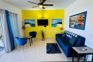 uma sala de estar com um sofá azul e uma televisão em Oceanfront Residence em Las Terrenas