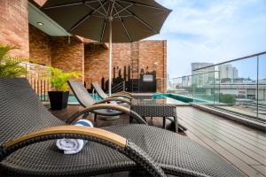 a group of chairs and an umbrella on a balcony at Santa Grand Classic Kuala Lumpur, Chinatown in Kuala Lumpur