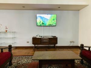 sala de estar con TV de pantalla plana en la pared en Departamento cómodo Cala Cala, en Cochabamba