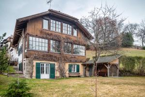 une grande maison en bois avec une porte verte dans l'établissement Haus Botter, à Collalbo