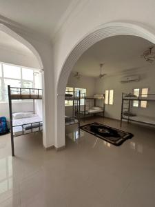a room with several bunk beds and an archway at Basil Hostel in Muscat