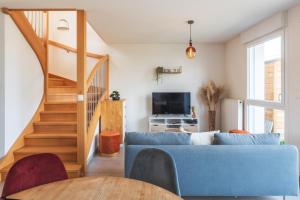 蘭戈爾桑的住宿－Nouveau - Sweet Garden - Maison avec jardin，客厅设有蓝色的沙发和楼梯。