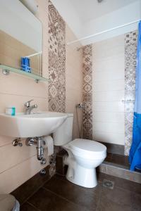 Stelios Hotel في سبيتسيس: حمام به مرحاض أبيض ومغسلة