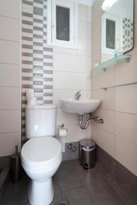 a bathroom with a toilet and a sink at Stelios Hotel in Spetses
