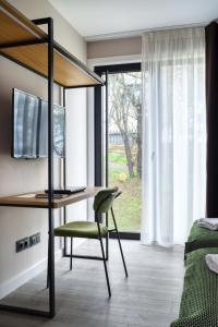 a bedroom with a desk and a green chair at HOTEL PORTOMARÍN STAR in Portomarin