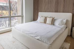 a white bed with two pillows on it in a bedroom at 128 Union in Traverse City