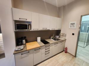 a kitchen with white cabinets and a microwave at Luxury Apartment Acropolis Syggrou in Athens