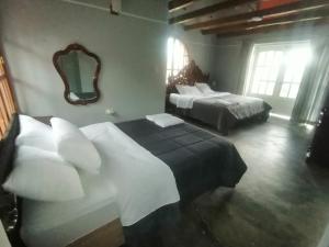 um quarto de hotel com duas camas e um espelho em Casa de campo completa a 20 minutos de Cajamarca Aire puro fogata y mas em Cajamarca